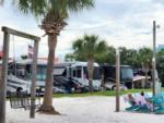 People relaxing in Adirondack chairs near the dock at PERDIDO KEY RV RESORT - thumbnail