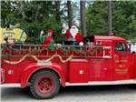 Santa and elves in a vintage fire truck - thumbnail