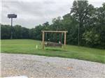 A swinging bench on a grassy area at MONTGOMERY SOUTH RV PARK & CABINS - thumbnail