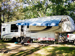 An RV parked in a shady site - thumbnail