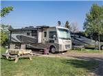 Large RVs parked in gravel sites with picnic tables at CHRIS' CAMP & RV PARK - thumbnail