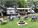 View larger image of People sitting around a fire pit at SID TURCOTTE PARK CAMPING AND COTTAGE RESORT image #6