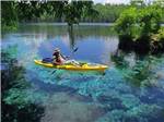 View larger image of A man using a kayak in crystal blue water at FLORIDA CAVERNS RV RESORT AT MERRITTS MILL POND image #1