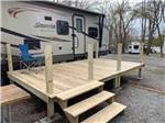 View larger image of A wooden deck next to a trailer at SKYLINE RV RESORT image #7