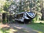 A fifth wheel trailer in a back in RV site at HAPPY LAND RV PARK - thumbnail