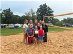 A group of kids on a beach volleyball court - thumbnail