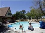 View larger image of Community swimming pool with children playing at SAC-WEST RV PARK AND CAMPGROUND image #5