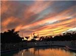 Colorful sunset erupting in the sky behind community pool at BONITA LAKE RV RESORT - thumbnail