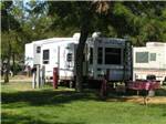 A fifth wheel trailer under a tree at HAT ROCK CAMPGROUND - thumbnail