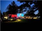 An outside movie screen showing at night - thumbnail