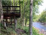 View larger image of A wooden cabin with a deck at SINGING WATERS CAMPGROUND image #7