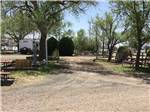 View larger image of A gravel road between RV sites with picnic benches at OVERNITE RV PARK image #5
