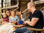 A young family laughing together outside their cabin - thumbnail