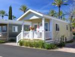 A couple standing on the porch of one of the manufactured homes at GOLDEN VILLAGE PALMS RV RESORT - thumbnail