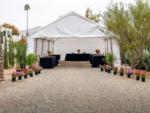 A white tent with covered tables under it at GOLDEN VILLAGE PALMS RV RESORT - thumbnail