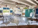 View larger image of White chairs pulled up to tables under ceiling fans at BIG PINE KEY RESORT image #7