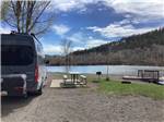 Van parked next to picnic table on the waterfront at Pagosa Riverside Campground - thumbnail