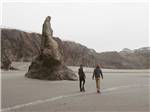 Couple walking on beach near unique rock formation at BANDON RV PARK - thumbnail
