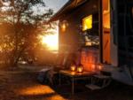 Parked RV with sun setting at Antlers Resort & RV Park - thumbnail