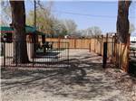 A fenced in RV site with a gazebo at CEDAR CITY RV RESORT BY RJOURNEY - thumbnail