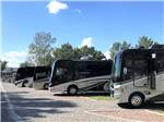 A row of motorhomes in gravel sites at CEDAR CITY RV RESORT BY RJOURNEY - thumbnail