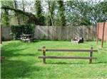 View larger image of A green grassy area with a fence at REDWOOD COAST CABINS  RV RESORT image #6