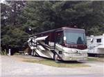 View larger image of Brown tan and white motorhome parked at VILLAGE CAMPER INN RV PARK image #7
