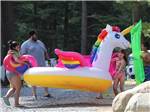 View larger image of A family holding an inflatable unicorn at LAKE GEORGE RIVERVIEW CAMPGROUND image #3