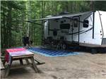A travel trailer parked at a campsite at LAKE GEORGE CAMPING VILLAGE - thumbnail