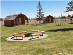 Wooden cabins with picnic benches at LARAMIE RV RESORT BY RJOURNEY - thumbnail