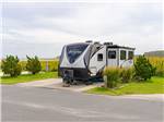 A fifth wheel trailer parked in a paved site at SUN OUTDOORS FRONTIER TOWN - thumbnail