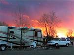 A motorhome and SUV parked at sunset at CORTEZ RV RESORT BY RJOURNEY - thumbnail