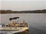 View larger image of People on a pontoon boat at HARMONY LAKESIDE RV PARK  DELUXE CABINS image #2