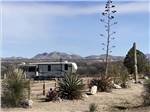 A travel trailer in a site with the mountains in the distance at BENSON KOA JOURNEY - thumbnail