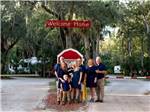 Group of people under welcome sign at SUGAR MILL RUINS TRAVEL PARK - thumbnail