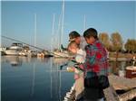 View larger image of A couple of young boys fishing off a dock at BOARDMAN MARINA  RV PARK image #6