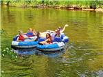 A family in inner tubes in the river at BIG CEDAR CAMPGROUND & CANOE LIVERY - thumbnail