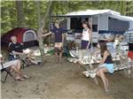 A group of people eating outside of a pop up tent at AVALON CAMPGROUND - thumbnail