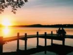 A couple sitting on the pier at sunset at BAR HARBOR RV PARK & MARINA - thumbnail