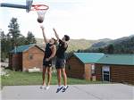 Two men playing basketball at JELLYSTONE PARK ESTES - thumbnail