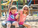 Kids on a tire swing at JELLYSTONE PARK ESTES - thumbnail