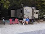 A couple sitting in front of their RV at BUCK CREEK RV PARK - thumbnail