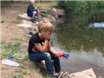 A child fishing in the lake at LONE DUCK CAMPGROUND - thumbnail
