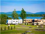 Large trailers and RVs parked alongside large lake at NARROWS TOO CAMPING RESORT - thumbnail