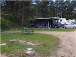 A picnic table at an empty RV site at SPRUCE LAKE RV RESORT - thumbnail