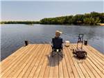 View larger image of A man fishing on the dock at OTTER LAKE CAMP RESORT image #5