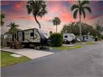 Trailers parked at campsites at sunset at NORTHTIDE NAPLES RV RESORT - thumbnail