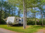 A travel trailer parked at a site - thumbnail