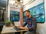 Man sitting at table on computer in RV at WHIP IN RV PARK - thumbnail