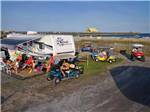 View larger image of A group of people driving golf carts around at APACHE FAMILY CAMPGROUND  PIER image #1